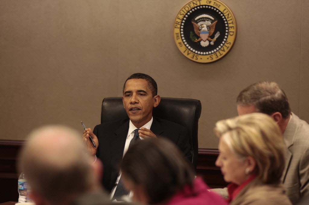 President Obama speaks from the head of the Situation Room table beneath the presidential seal, with Secretary of State Hillary Clinton at right, during a meeting on Afghanistan and Pakistan.