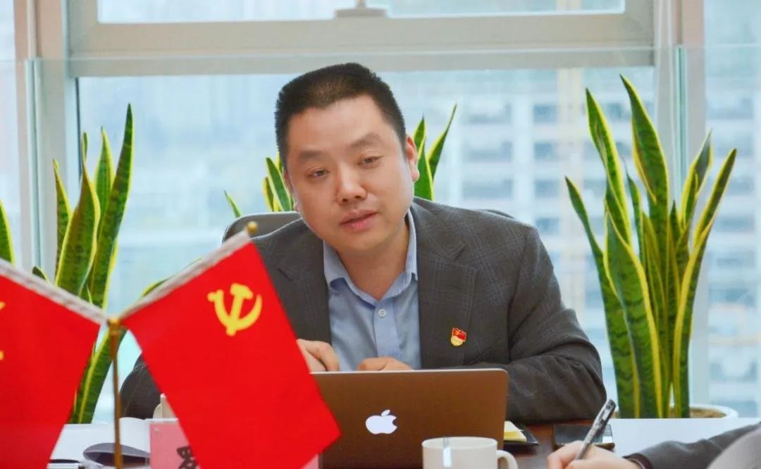 Man in a suit at a desk with CCP flags, as published by henghexin.com
