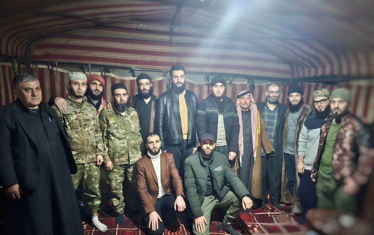 Al-Julani in a group photo inside a tent with local men and fighters, February 13, 2024.