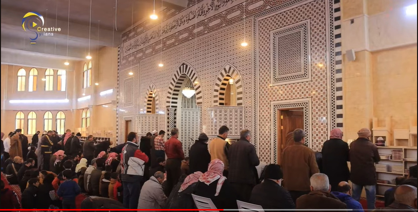 Interior of the Zayd bin Haritha Mosque during the opening, with striped arches and lattice wall panels.